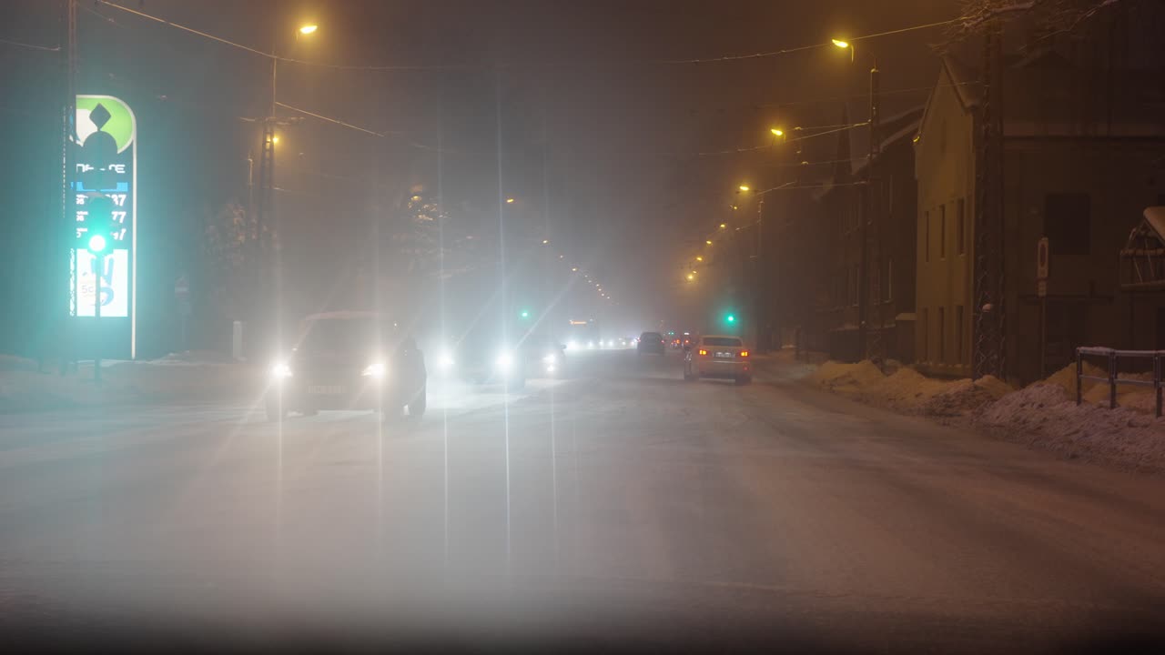 겨울 밤, 리가, 라트비아에 자동차로 바쁜 메인 스트리트의 눈 덮인 장면