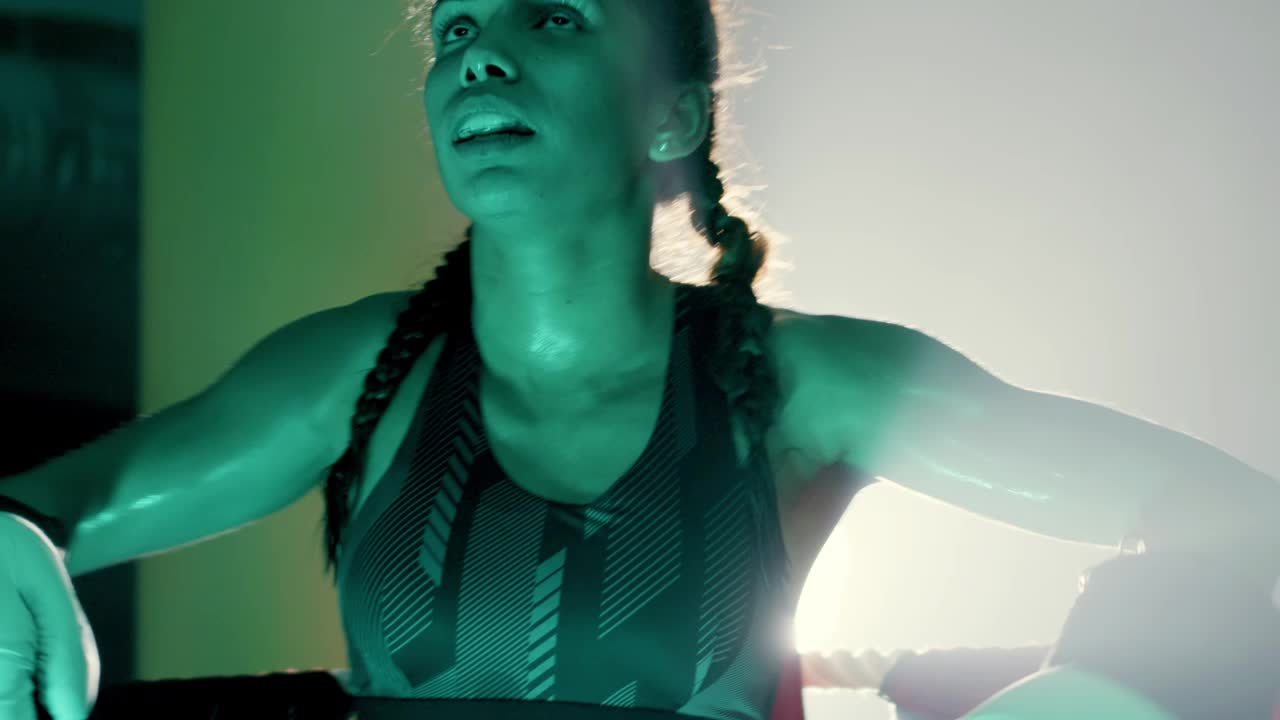 지친 여성 권투 선수가 훈련 세션을 마치고 휴식을 취하기 위해 그물에 가다