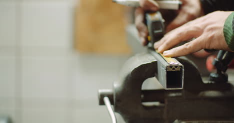 hombre que trabaja en la industria metalúrgica cortando y midiendo piezas metálicas en el taller 6