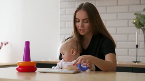 madre y bebé jugando con una tableta digital