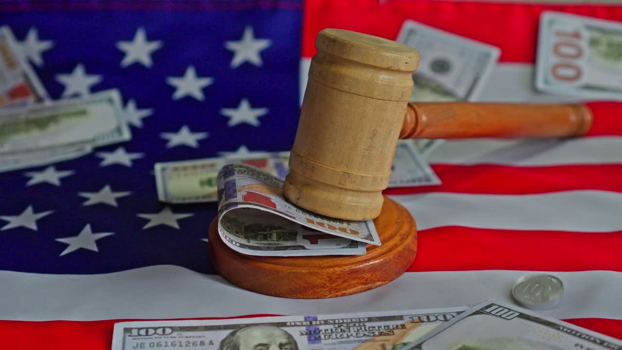 Soldi che piovono su un martelletto da giudice e una bandiera americana.