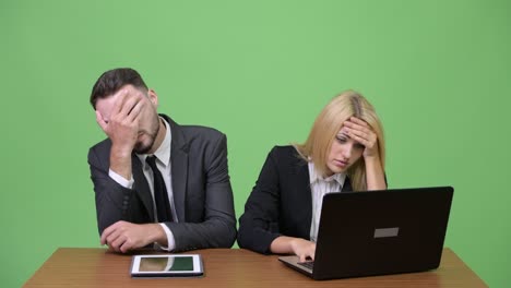 young stressed business couple using laptop together and getting bad news
