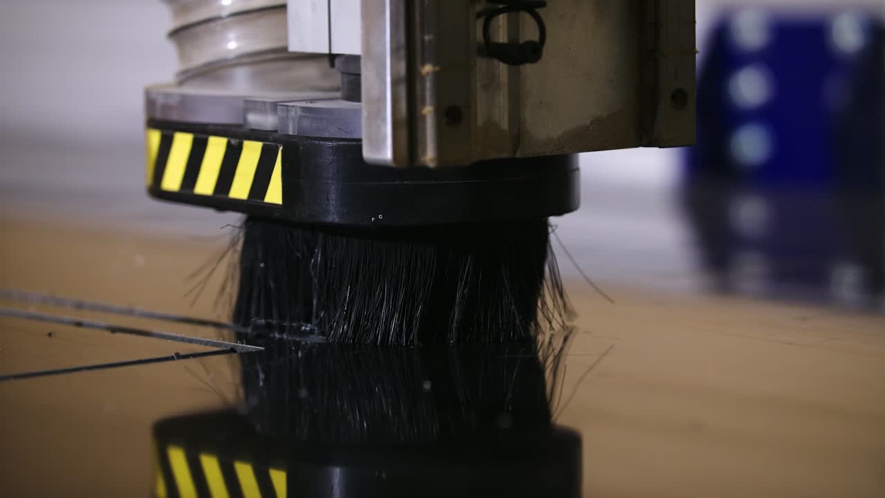 A tight shot of a tabled CNC router cutting black signage in slow motion