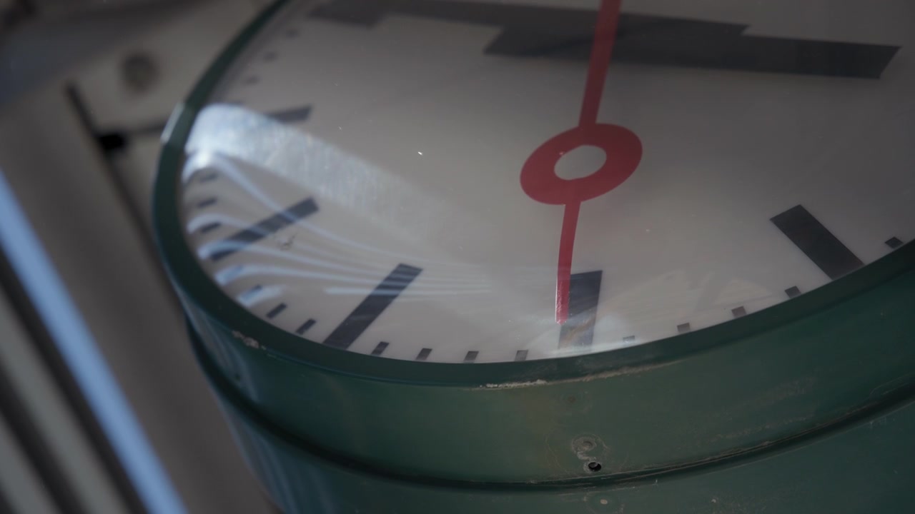 Metal public clock with red arrow
