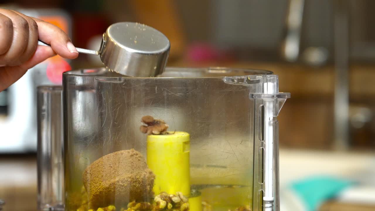 흑설탕을 푸드 프로세서에 넣고 호두와 섞어 커피 케이크를 만드는 것 - 슬로우 모션 틸트 다운 공개