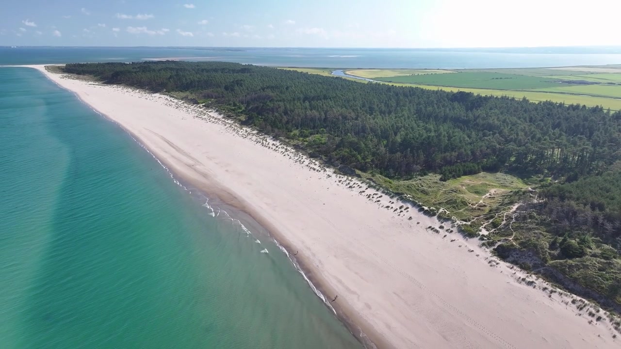 Vacker kustlinje vid Curracloe Beach med kristallklart hav, flygfoto över irländskt landskap