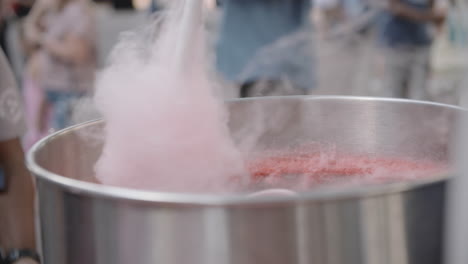 Slow-motion-footage-of-a-hand-spinning-cotton-candy-around-a-machine