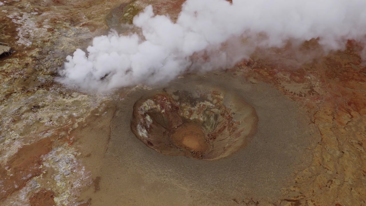 Gunnuhver Geothermal Area, Reykjanesbaer, Southern Peninsula, Iceland, revealing a boiling mud pool, dense steam plume, hydrothermal alteration and mineral deposits, top-down static shot.