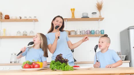 Happy Mother Daughter and Son Having Fun Dancing to Music in the Kitchen while Cooking Happy Mother Daughter and Son Having Fun Dancing to Music in the Kitchen while Cooking Family Look Happy together at Home