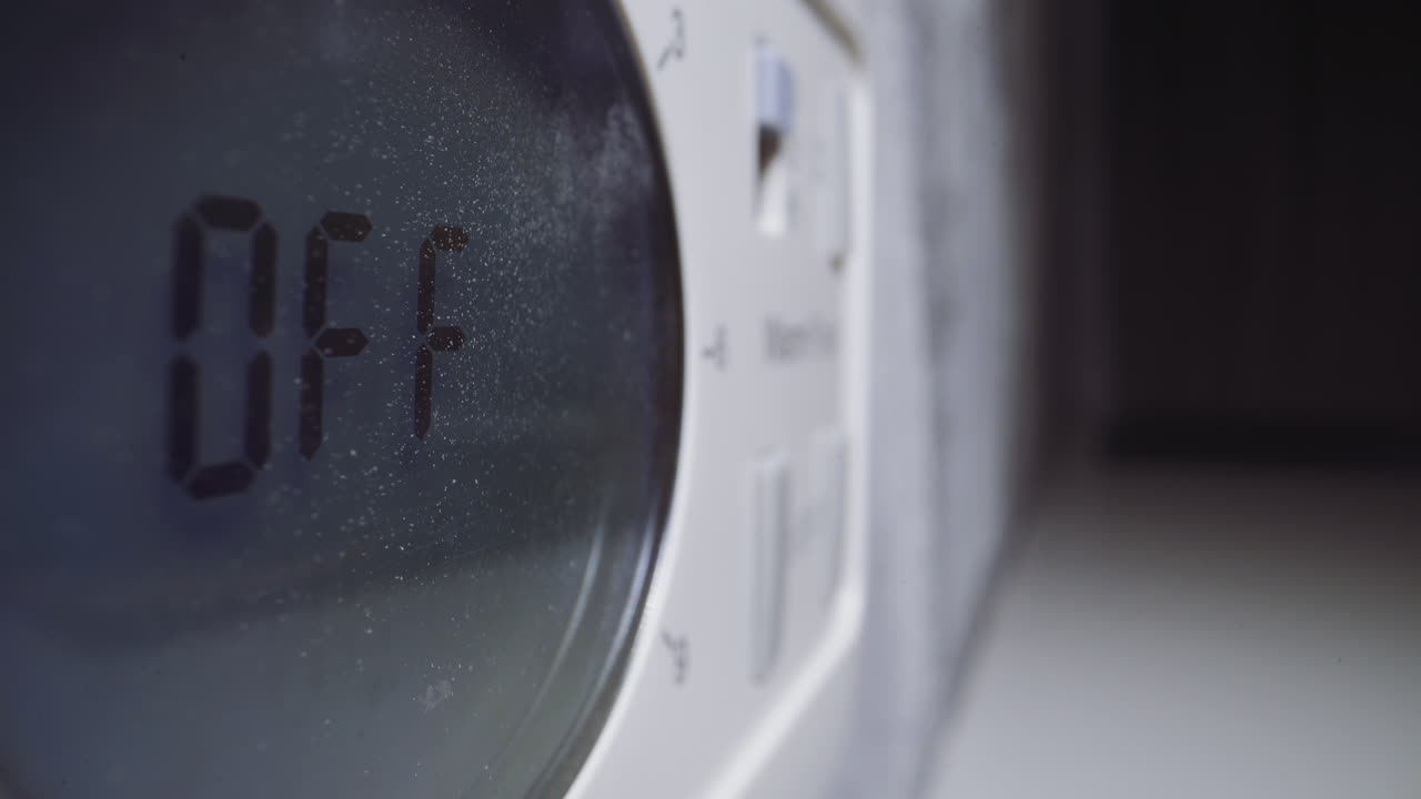 여자가 마이크로웨이브 오븐의 제어 패널에서 타이머를 꺼 ⁇ 니다.