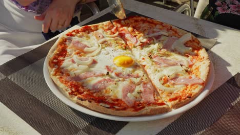 Hand-of-person-slice-pizza-with-steel-wheel,-close-up-view