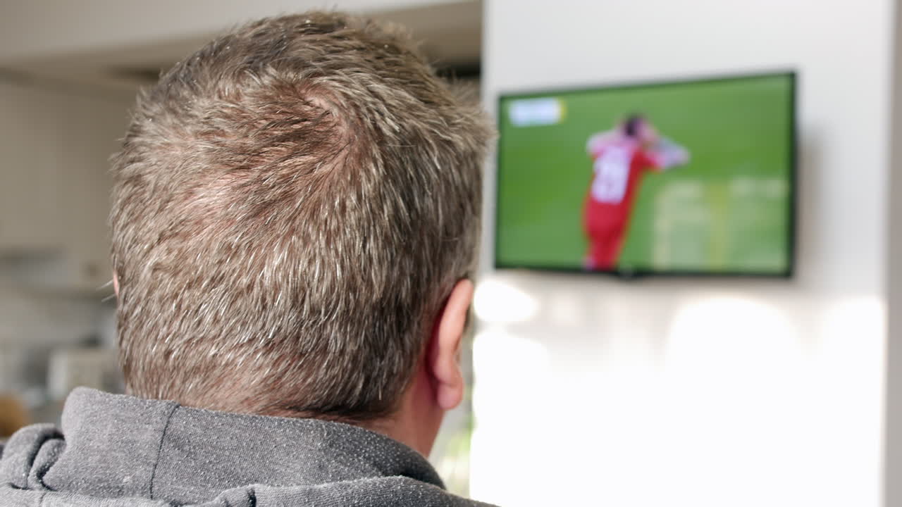 Un uomo che guarda una partita di calcio in TV