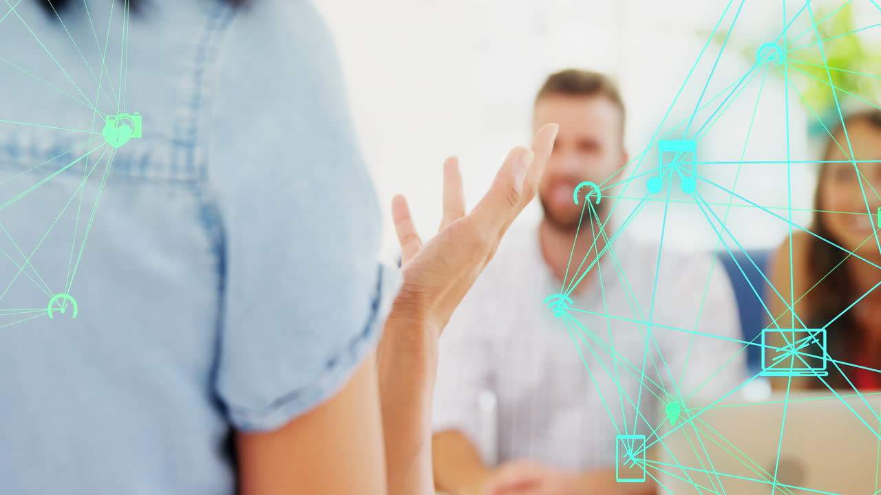 анимация глобусов цифровых икон над задним видом женщины, обсуждающей с коллегами в офисе