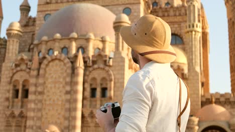 tourist stands against the background of a muslim shrine