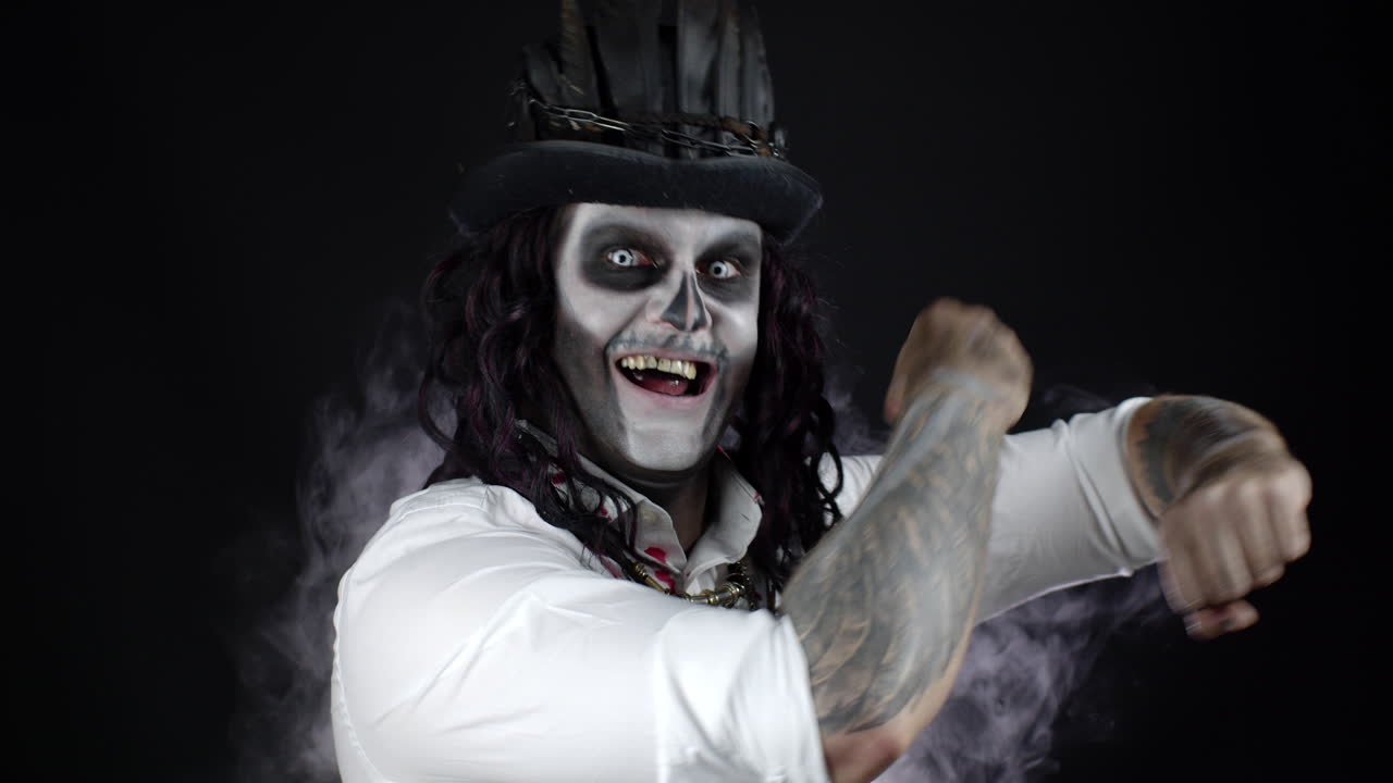 피 묻은 셔츠를 입은 골격 할로윈 메이크업을 가진 끔찍한 남자. 음악을 듣고, 춤을 추고, 축하하는 남자