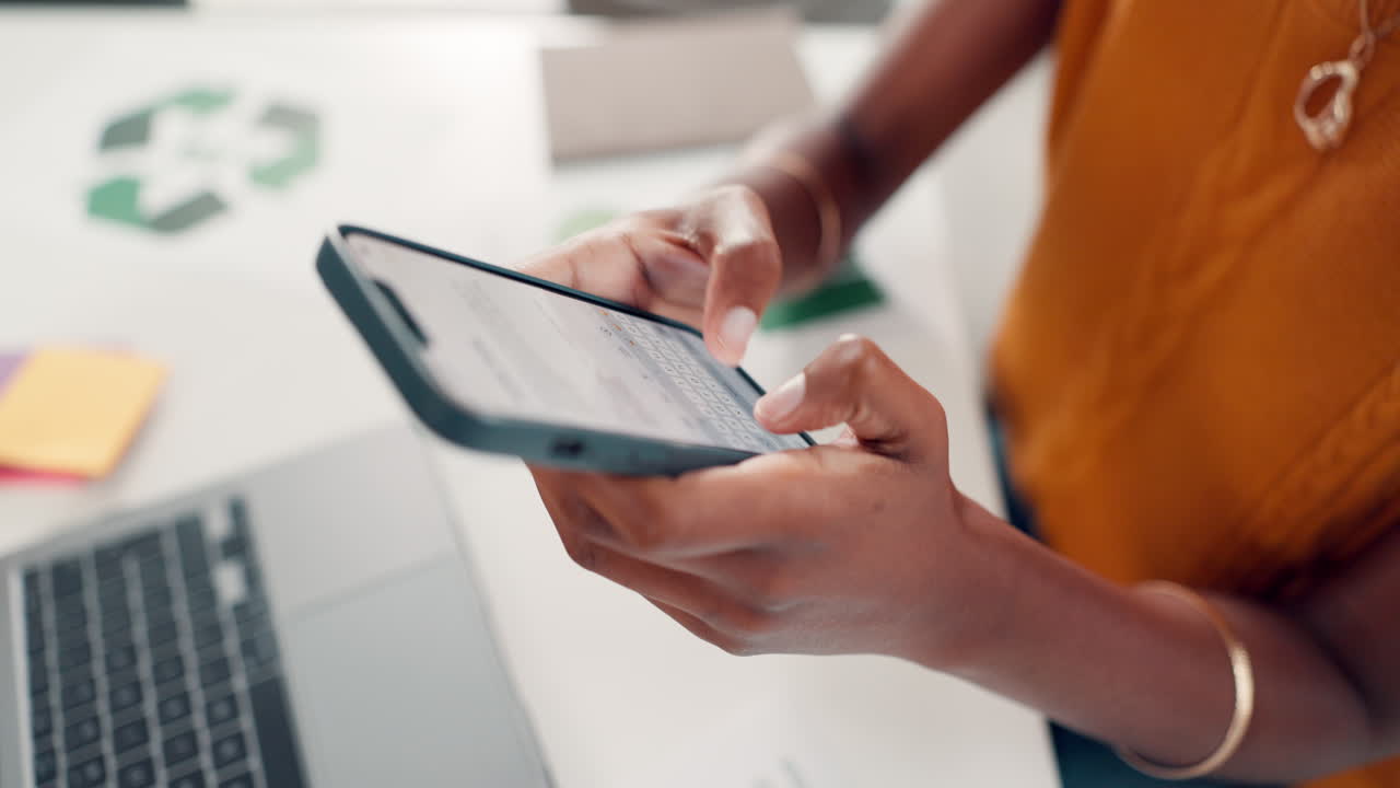 Close Up of Hands Typing on a Smartphone in an Office