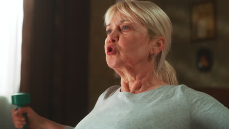 elderly woman exercising at home with dumbbells