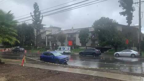 lluvia cayendo en una concurrida calle residencial