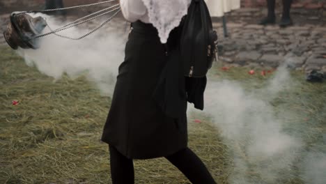 person carrying burning incense on holy thursday procession in antigua, guatemala