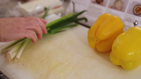 Primer-Plano-De-Una-Mujer-Colocando-Comida-En-Una-Tabla-De-Cortar-En-4k