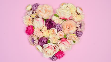 bloom spring flowers make heart shape on pastel pink theme. stop motion