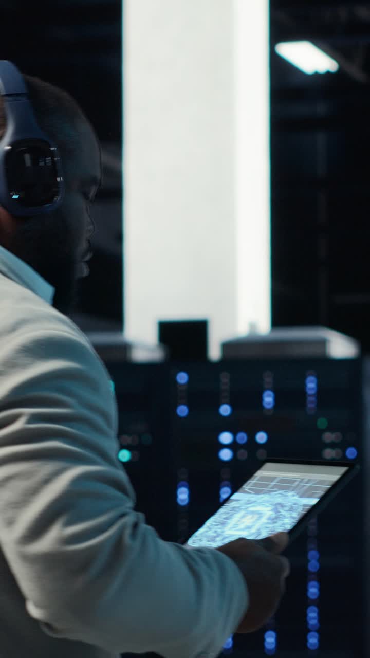 Vertical video Admin walking in data center, listening music while doing inspection