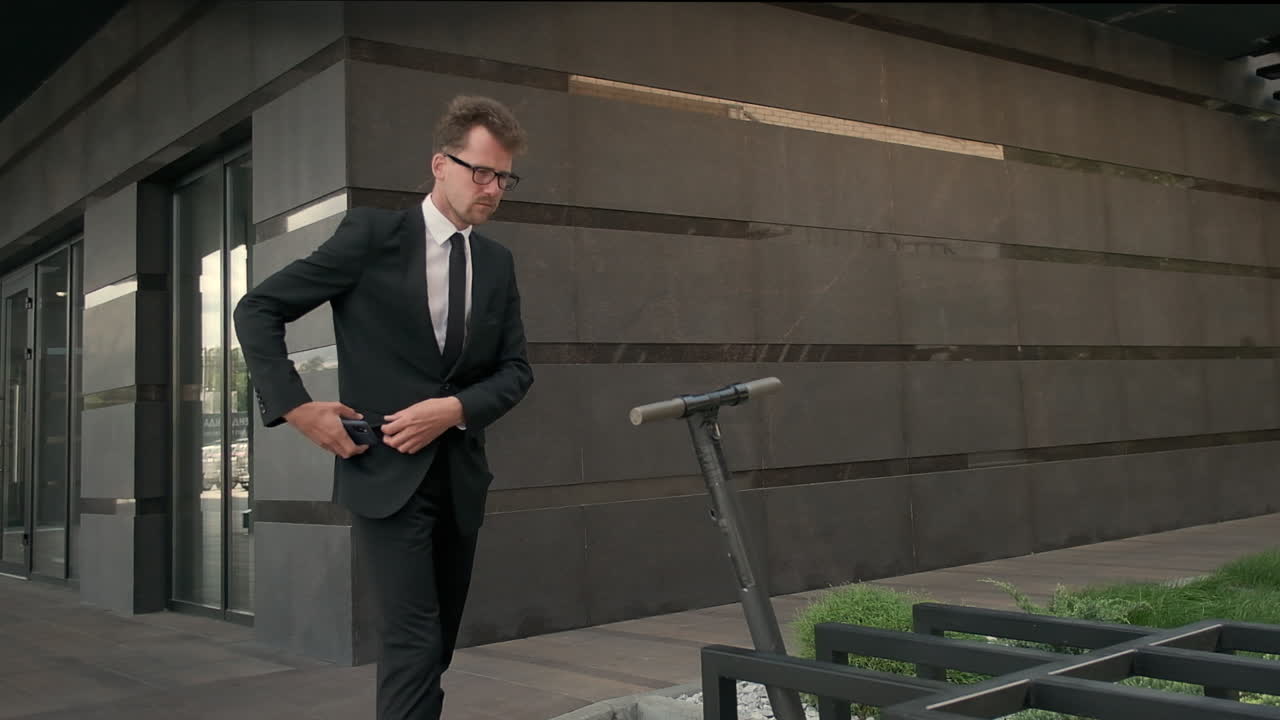 hombre de negocios usando scooter eléctrico cerca del edificio de oficinas