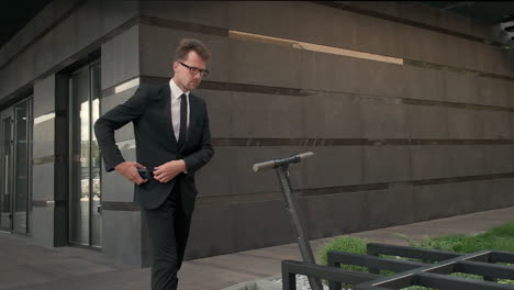 businessman using electric scooter near office building