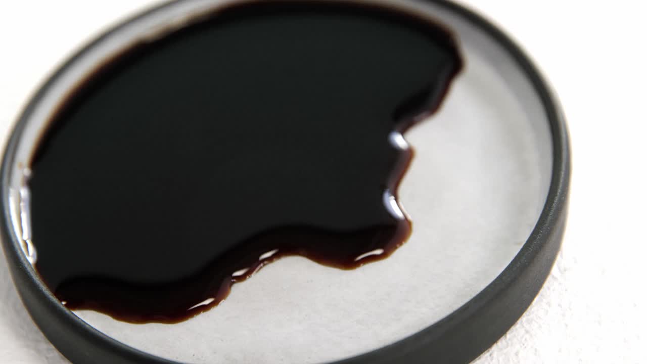 plato pequeño con salsa de soja sobre fondo blanco