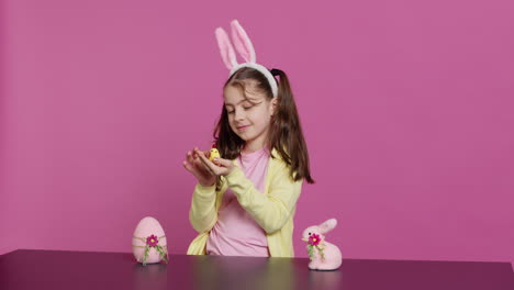 joyful little girl playing with festive easter decorations in studio