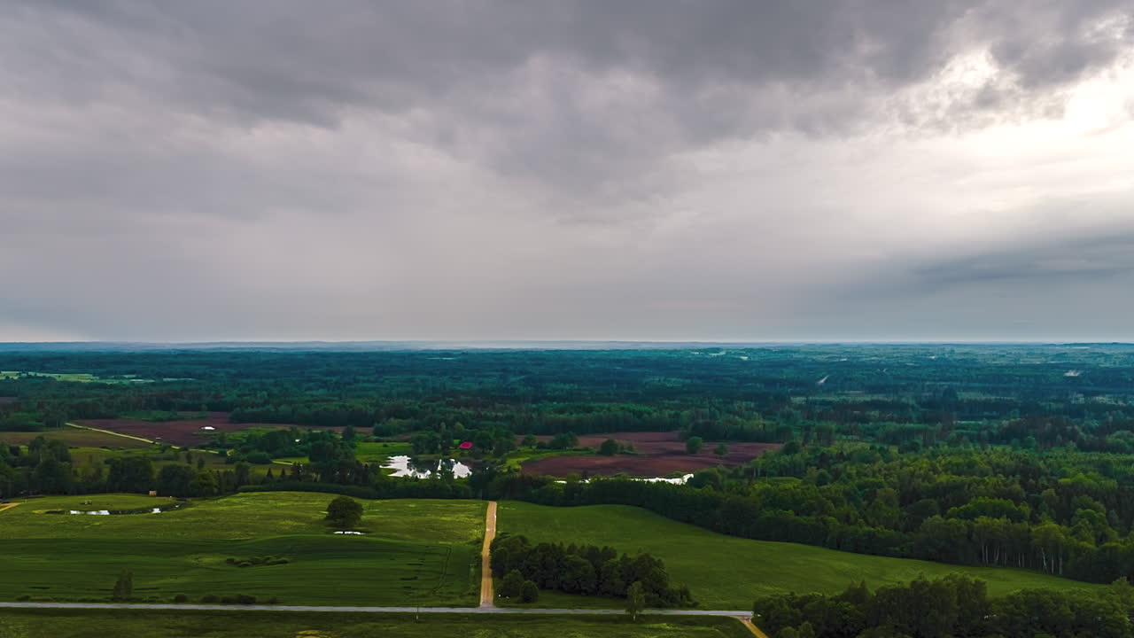 Time lapse of clouds forming over valley with rolling green hills, swirling towards viewer