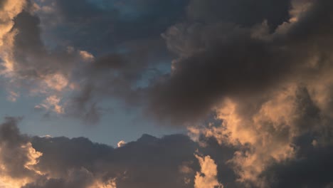 un suave lapso de tiempo de una dramática puesta de sol, nubes de surf de colores, azul y naranja, hora dorada hora del anochecer