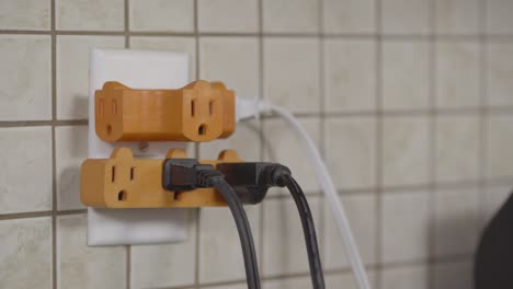 an outlet is fitted with plug splutters and several cords are plugged in already