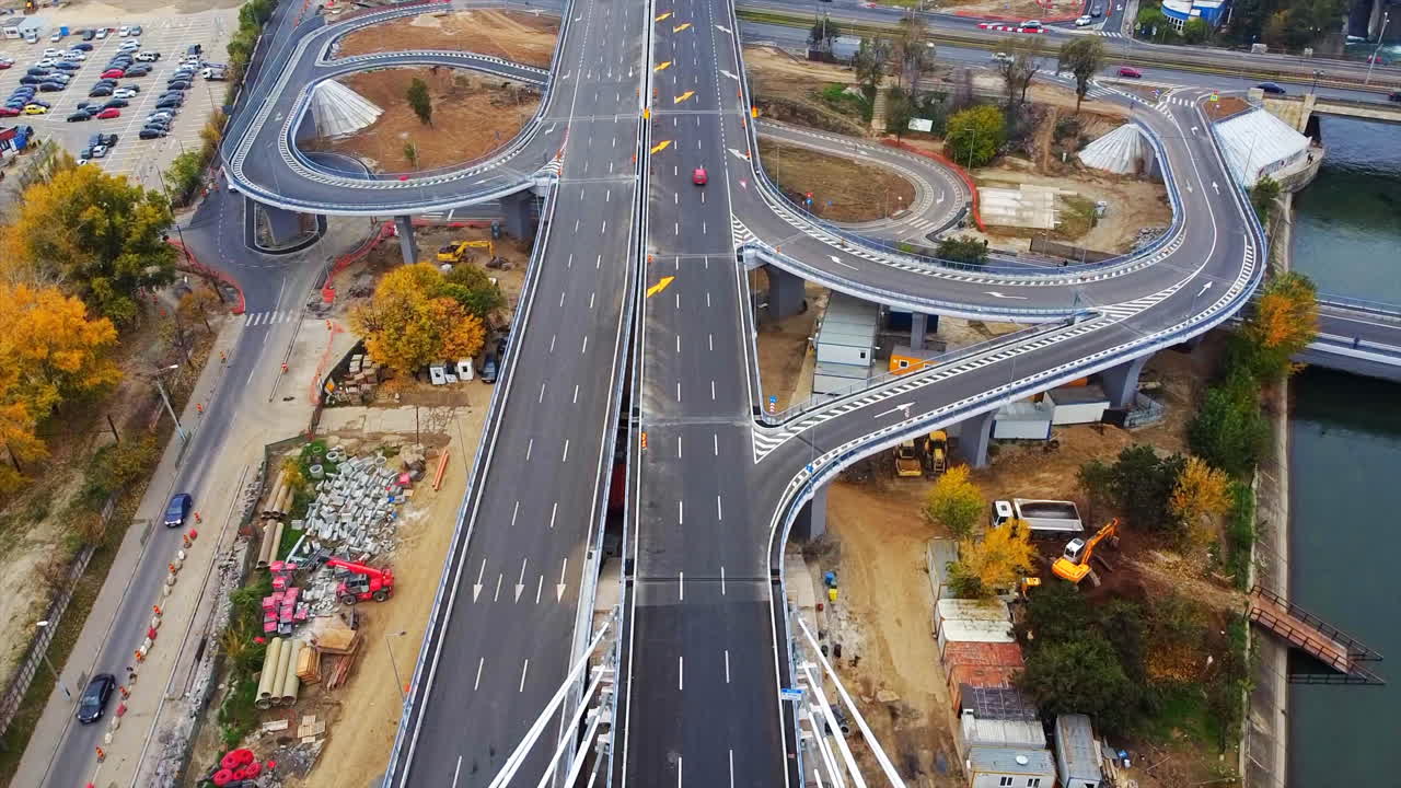 Ciurel passage, bridge over a river with moving cars, construction works near it. View from the drone. Bucharest, Romania