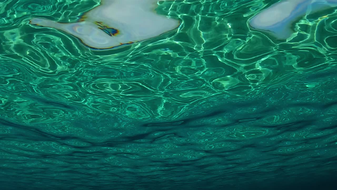 파도와 잔물결의 움직임이 있는 맑고 투명한 바다 수면의 실제 색상 수중 장면