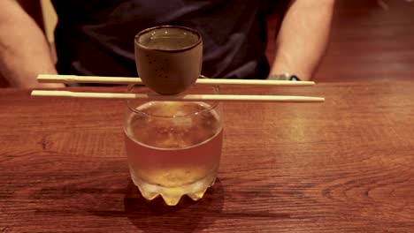 man prepares a sake bomb drink