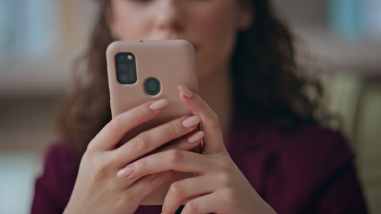 Donna di successo che digita sul cellulare al lavoro. Primo piano delle mani che tengono il telefono.