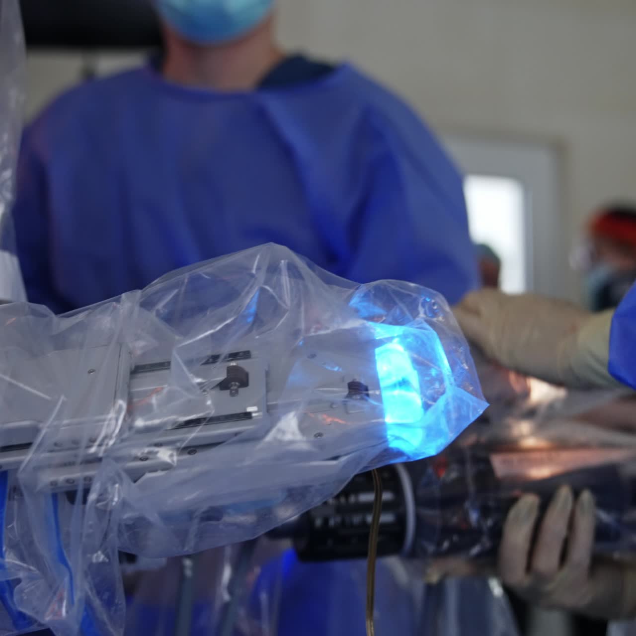 Male doctor passes a manipulator arm to a female colleague. Modern surgery of minimal invasion involving robotic surgery system