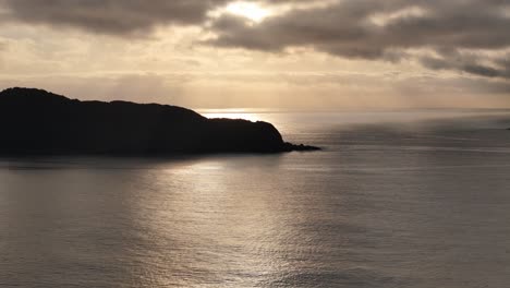 Golden-Sunset-Over-Tranquil-Waters:-An-Isolated-Island's-Silhouette-Bathed-in-Ethereal-Light