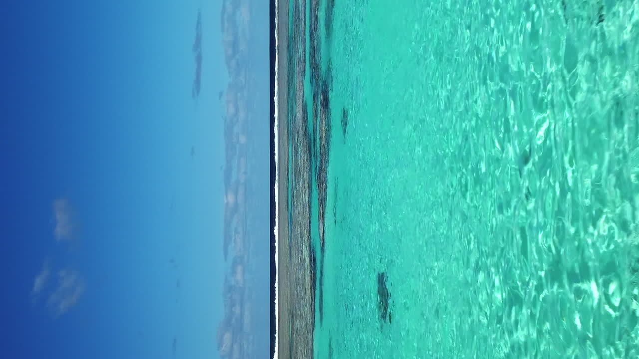Movimento dolly verticale basso in avanti sopra acque cristalline, barriera corallina, isola di Maré