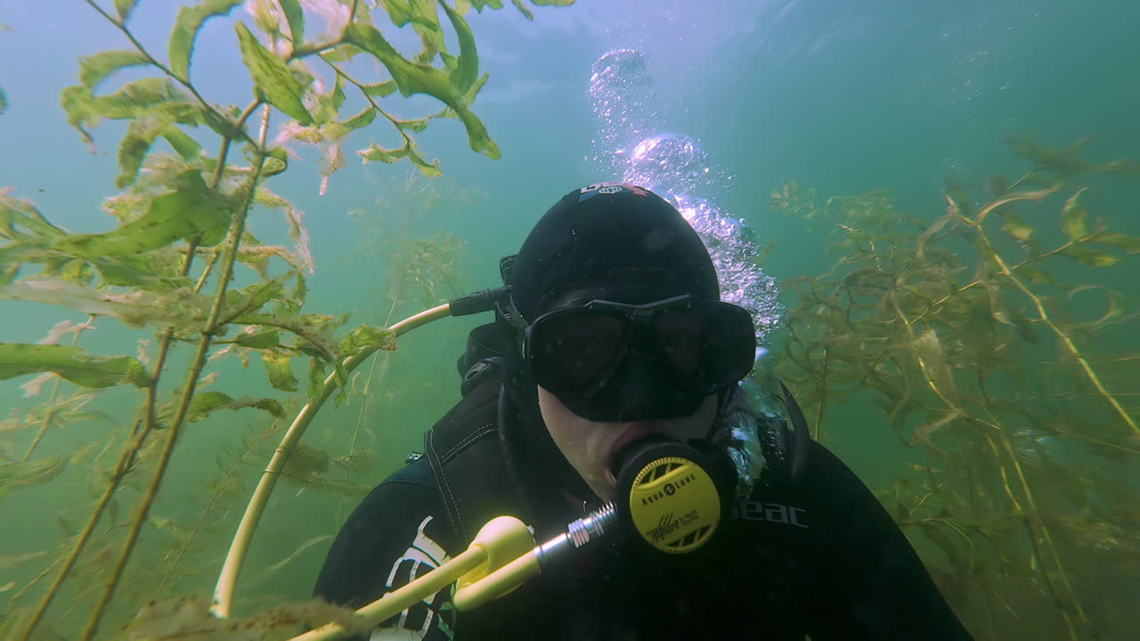 diver face POV, scuba diver man wearing a mask, water bubbles, scuba air oxygen tank to breath while snorkeling, underwater gear, dive equipment
