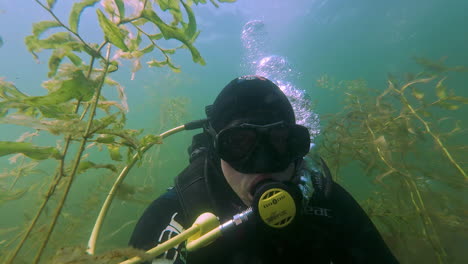 diver face pov, scuba diver man wearing a mask, water bubbles, scuba air oxygen tank to breath while snorkeling, underwater gear, dive equipment