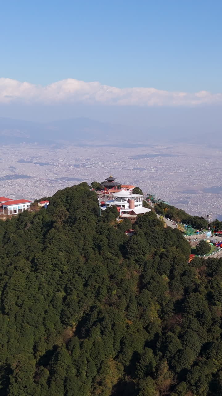 Vertical drone shot rising aroundm the Chandragiri hill, in sunny Kathmandu,Nepal