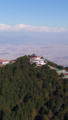 vertical drone shot rising aroundm the chandragiri hill, in sunny kathmandu,nepal