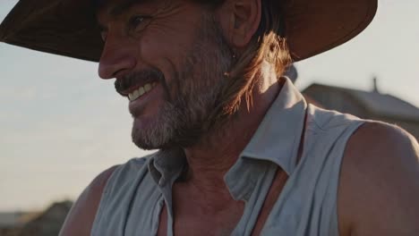 smiling farmer in field at sunset