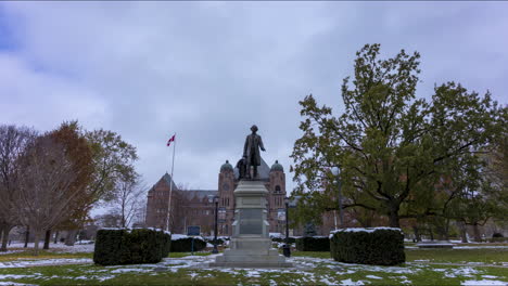 timelapse of the statue in front of the ontario legislative building in toronto with looming stormy, overcast sky behind