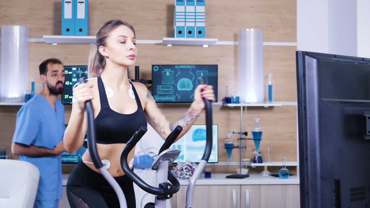 여자 운동 선수 가 달리는 동안 tv 스크린 을 보고 있다