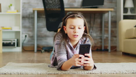 Cheerful-little-girl-lying-on-the-floor-carpet