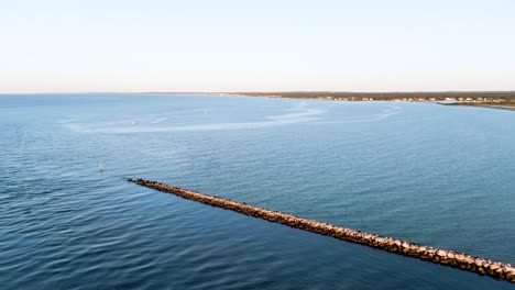 Aerial-tilt-down-view-in-the-sea-and-barriers-in-stone-serving-as-corridors-for-boats