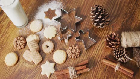 video of christmas decorations with an assortment of cookies and glass of milk on wooden background